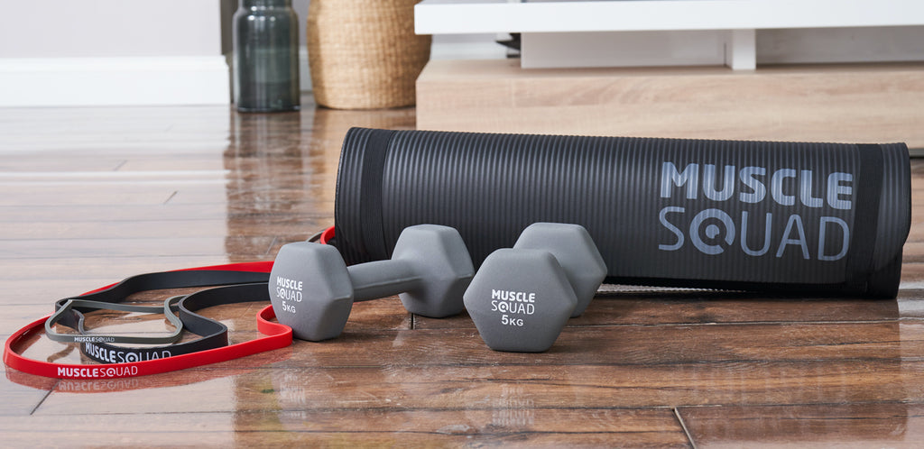 Neoprene Dumbbells Gym Mat and Resitance bands on the floor ready for a core workout to show cheap gym equipment can be effective.